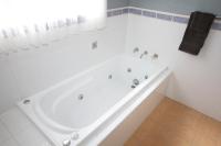a white bath tub in a white bathroom at Acacia Snowy Motel in Jindabyne