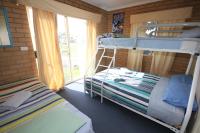 a bedroom with two bunk beds and a window at Acacia Snowy Motel in Jindabyne
