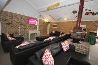 a living room with couches and a brick wall at Acacia Snowy Motel in Jindabyne
