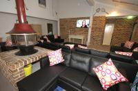 a living room with a couch and a fireplace at Acacia Snowy Motel in Jindabyne
