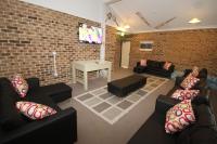a living room with couches and a brick wall at Acacia Snowy Motel in Jindabyne
