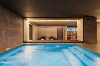 Una piscina en una habitación de hotel con un gran espejo. en Eurostars Matera La Suite, en Matera