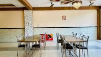 a dining room with wooden tables and chairs at Hotel Palash in Godarpura