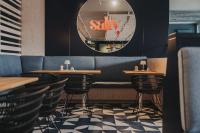 ランゲオークにあるSilt & Sand Langeoogの鏡とテーブルと椅子が備わるレストラン