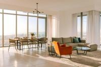 Una sala de estar con un sofá, una mesa y sillas. en Sonder by Marriott Bonvoy Downtown Towers Apartments, en Dubái