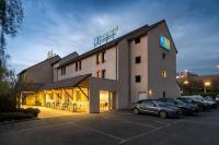 シャントピにあるSure Hotel by Best Western Rennes Chantepieの駐車場に車が駐車されている建物