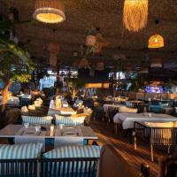 un ristorante con tavoli e sedie bianchi e luci di Twin studio by White Tower a Mamaia