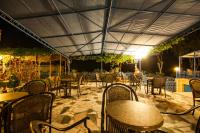 an outdoor patio with tables and chairs at night at Hotel Philoxenia in Masouri
