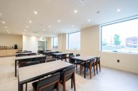 a classroom with tables and chairs and a large window at BrownDot Hotel Hongseong Naepo in Hongseong