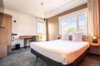 Una habitación de hotel con una cama, un escritorio y una ventana. en Hôtel AKENA Chalons-en-Champagne, en Châlons-en-Champagne