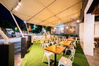 un ristorante con tavoli in legno e sedie bianche di Stark Boutique Hotel and Spa a Kuta