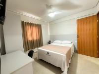 Un dormitorio con una cama y una mesa y una ventana. en Hotel Milenio, en Ponte Nova