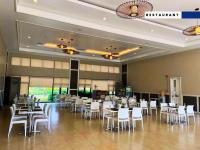 TanzaAquamira Hotel & Resort的一间设有白色桌子和白色椅子的餐厅