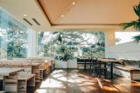 Ao-shimaAoshima Picnic Club的一家有桌椅和大窗户的餐厅