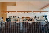 Ao-shimaAoshima Picnic Club的一个带柜台的厨房和一个准备食物的人