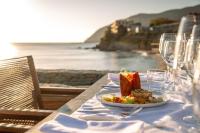 a plate of food on a table with a view of the ocean at Porto Plomari in Plomarion