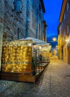 La Locanda Del Brolio في Cantiano: مجموعة طاولات عليها انارة على شارع