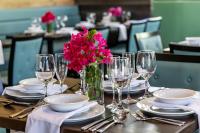 una mesa con platos y vasos y un jarrón de flores en Ocean Breeze Resort, en NCA