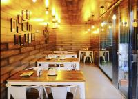 新德里Hotel The Teo Near Delhi AIRPORT的一间有桌椅的餐厅