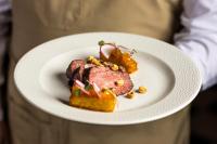 uma pessoa segurando um prato com um pedaço de alimento em UNAI Atacama Luxury Tents em San Pedro de Atacama