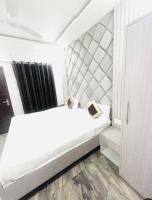 Ein weißes Bett in einem kleinen Zimmer mit in der Unterkunft Hotel Green Apple BAREILLY in Bareilly