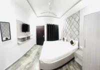 ein weißes Schlafzimmer mit einem Bett und einem Fernseher in der Unterkunft Hotel Green Apple BAREILLY in Bareilly
