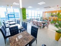 a restaurant with tables and chairs and people sitting at tables at Bojon Hotel Ulaanbaatar - Soyolj Mall in Ulaanbaatar