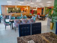 a restaurant with tables and chairs and a cafeteria at Bojon Hotel Ulaanbaatar - Soyolj Mall in Ulaanbaatar