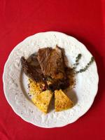 a plate with a piece of meat on a red table at Redil del Paraíso in La Cumbre