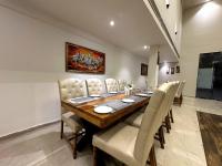 a dining room with a wooden table and white chairs at The Imperial Prime in Bhilwara
