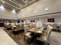 a dining room with a long table and chairs at The Imperial Prime in Bhilwara