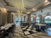a banquet hall with tables and chairs and windows at Alhamra Hotel in Mardan