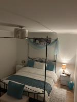 Un dormitorio con una cama con dosel y almohadas azules. en Chambre Zen Et Calme, en Bouveret