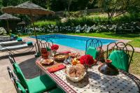 una mesa con comida y flores junto a una piscina en Atlas Smile Retreat, en Tassa Ouirgane