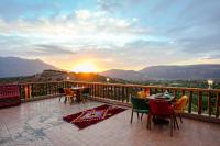 un balcón con mesas y sillas y vistas a la puesta de sol en Atlas Smile Retreat, en Tassa Ouirgane