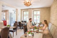 un homme et une femme assis à une table dans un restaurant dans l'établissement Landhotel am Wasserrad, à Meisenheim