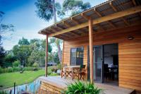 a house with a wooden deck with a table at Lorne Foreshore Caravan Park in Lorne