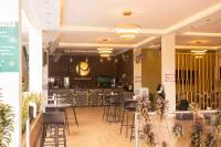 een restaurant met tafels en stoelen en een bar bij Parkview Hotel in Accra