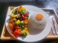 Un plato de arroz y verduras en una bandeja. en Discover Kratie Homesetay, en Kratié