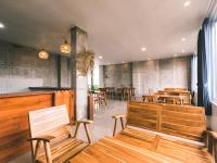 Un restaurante con mesas y sillas de madera y un bar. en Zavana rooms & Restaurant, en Tanjungkarang