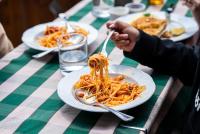 a table with plates of spaghetti on a table at Hotel Alpen Arnika in Tauplitzalm