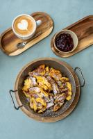 a plate of food in a pan with a cup of coffee at Hotel Alpen Arnika in Tauplitzalm