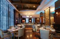 ein Restaurant mit Tischen und Stühlen in einem Raum in der Unterkunft Radisson Suites Bangkok Sukhumvit in Bangkok