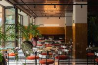 um restaurante com mesas, cadeiras e plantas em Bazzar Boutique Hotel em Tbilisi
