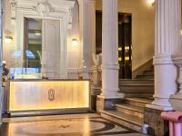 Un vestíbulo de un edificio con escalera y columnas. en Hôtel L&#39;orque Bleue, en Sète