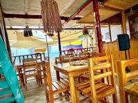 Un restaurante con mesa y sillas y una playa. en Shekina Club House, en Playa Blanca