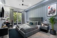 Un dormitorio con una cama grande y un sofá. en BedChambers Serviced Apartments, MG ROAD, en Gurgaon