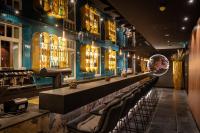 eine Bar in einem Restaurant mit einer Reihe von Stühlen in der Unterkunft Hotel Villa Hirzel in Schwäbisch Gmünd