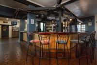 Una barra con cuatro taburetes en una barra en Hebron Haven Hotel, en Dargle