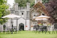 a group of tables and umbrellas in front of a castle at Abbey Hotel Roscommon in Roscommon